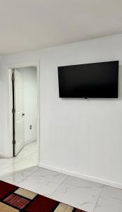 JamaicaMiad’s Guest House的客房内白色墙壁上的平面电视