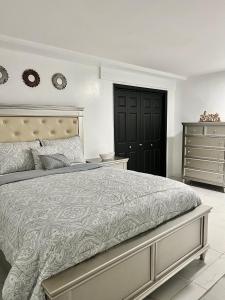 JamaicaMiad’s Guest House的一间卧室配有一张大床和一个梳妆台