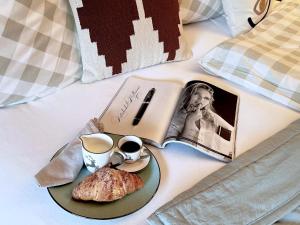 基茨比厄尔附近赖特KitzMoments by Belle Stay的床上的早餐盘,包括书籍、咖啡和糕点