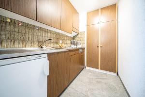 武尔佩拉4306 Liebevolle 1,5-Zimmer-Wohnung mit Balkon und traumhaftem Ausblick的厨房配有木制橱柜和白色的电器
