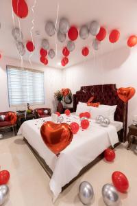 河内Royal Hotel Sài Đồng - Long Biên的一间卧室配有一张红色和银色气球床。
