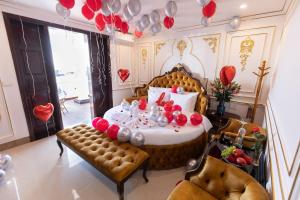 河内Royal Hotel Sài Đồng - Long Biên的一间设有一张桌子和一张带气球的床的房间