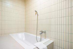 釜山Hound Hotel Haeundae Signature的带浴缸和淋浴的浴室