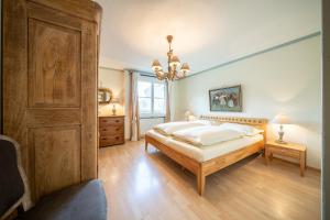 武尔佩拉5302 Grosszeugige 3,5 Zimmer Wohnung mit stilvoller Einrichtung的一间卧室设有一张大床和一扇木门