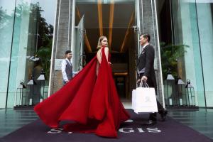 曼谷曼谷瑞吉酒店的穿着红色衣服的女人和装着购物袋的男人