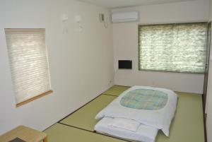 美瑛町惠雪笑颜绽放住宿加早餐旅馆的客房设有一张床和两个窗户。