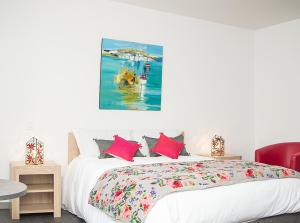罗卡马杜尔Les pirondeaux的卧室配有一张床,墙上挂有绘画作品