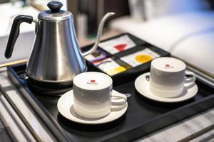 广州宜尚Plus酒店广州北京路步行街店的托盘上放两个咖啡杯和茶壶