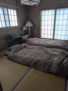 川越小江戸川越ハウス的配有窗户的客房内的一张大床