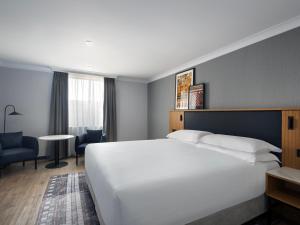 爱丁堡Edinburgh Marriott Hotel Holyrood的酒店客房设有一张白色大床和一张书桌