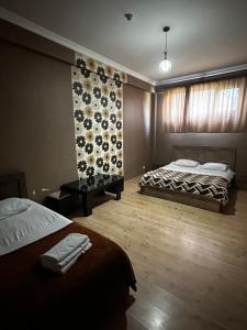 第比利斯Hotel Nirvana的一间卧室设有两张床和花卉墙
