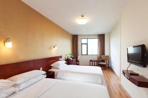 上海米乐酒店 - 上海虹桥国展中心九星店的酒店客房设有两张床和一台平面电视。