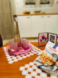 科扎尼Cozy place的一张桌子,上面有花瓶,放在带杯子的粉色盘子上