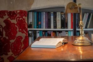 巴斯Somerset House Apartment - Charming Period 1BD的一张桌子上的开放式书,带灯
