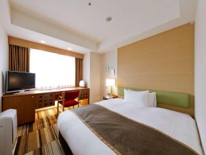 大阪路德会酒店的酒店客房配有一张床、一张书桌和一台电视。