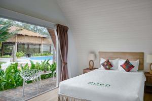 高龙撒冷岛Eden Beach Resort by EHM的一间卧室配有一张床,享有游泳池的景色