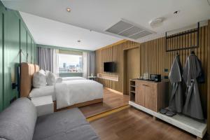 曼谷Maison Hotel Bangkok的酒店客房,配有床和电视