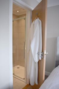 LeverburghGrimisdale Guest House的带淋浴的浴室和挂在门上的浴袍