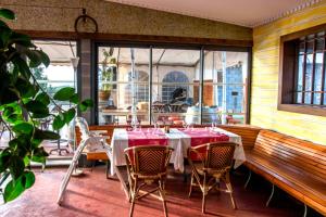 圣皮埃尔Gadiamb City的餐厅配有带粉红色桌椅的桌子