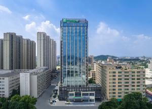 汕头汕头澄海智选假日酒店的一座高大的玻璃建筑,在城市里,有建筑