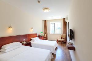 上海米乐酒店 - 上海虹桥国展中心九星店的酒店客房设有两张床和电视。