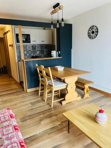 奥尔西埃Magnifique studio 4 pers avec balcon vue montagne的厨房以及带木桌和椅子的用餐室。