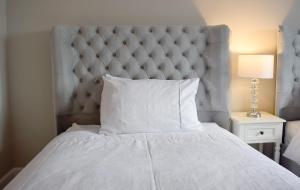 LeverburghGrimisdale Guest House的卧室配有一张白色的床和大型床头板