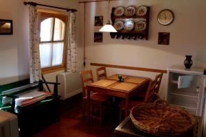 MagyarszombatfaAnna Lak的一间设有桌椅和墙上时钟的房间