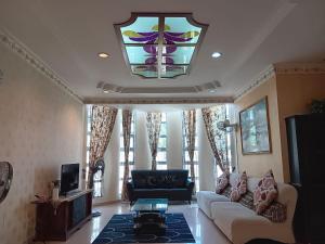 阿罗士打Homestay Banglo Alor Setar的带沙发和彩色玻璃窗的客厅