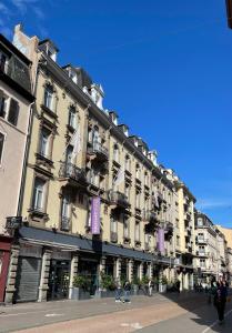 斯特拉斯堡斯特拉斯堡中心小法国美居酒店的街道上带紫色阳台的大型建筑
