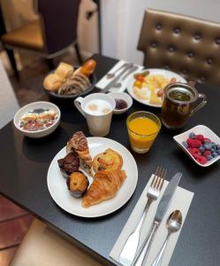 斯特拉斯堡斯特拉斯堡中心小法国美居酒店的一张桌子,上面放着早餐盘