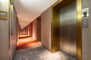 广州宜尚Plus酒店广州北京路步行街店的走廊上设有金属门和长长的走廊