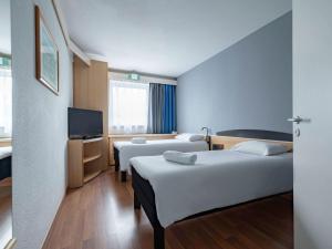 波兹南波兹南斯塔勒米亚斯托宜必思酒店的酒店客房设有两张床和一台平面电视。