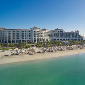 迪拜迪拜棕榈岛华尔道夫酒店的海滩上的酒店,配有椅子和遮阳伞
