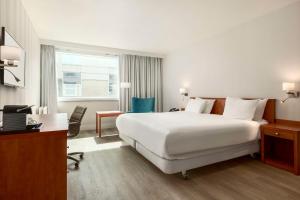 霍夫多普阿姆斯特丹史基浦机场NH酒店的酒店客房设有一张白色大床和一张书桌
