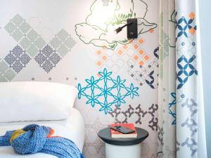 巴黎巴黎盖尔圣拉扎尔宜必思尚品酒店的一间卧室配有一张带雪花墙的床
