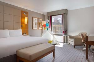 剑桥剑桥市中心希尔顿酒店的酒店客房带一张床铺、一张书桌和一间卧室