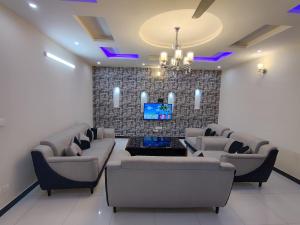 伊斯兰堡Luxury Holiday Home in Islamabad的带沙发和平面电视的客厅