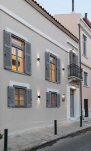 雅典New Villa In Downtown的白色的房子设有窗户和阳台
