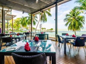 乔治市Mercure Penang Beach的一间带桌椅的海景餐厅