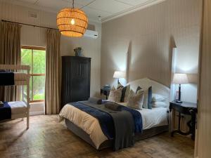 博福特西The Merino Guest House - B&B的一间卧室配有一张大床和一盏灯