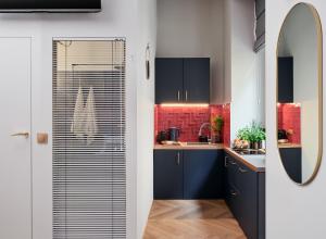罗兹Hidden Garden Apartments的厨房配有蓝色橱柜和红色瓷砖