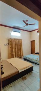 JagdalpurSangeeta's Homestay的一间卧室配有两张床和吊扇