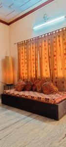 JagdalpurSangeeta's Homestay的橙色窗帘的房间的一张床位