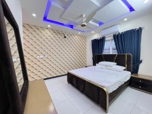 伊斯兰堡Luxury Holiday Home in Islamabad的一间卧室设有一张床和蓝色的天花板