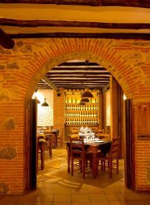 Villanueva del CondeAlojamiento Rural Villanueva del Conde的一间设有木桌和砖墙的用餐室