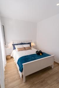 阿里纳加Sunny Winter Arinaga的一间卧室配有一张白色的床和蓝色的毯子