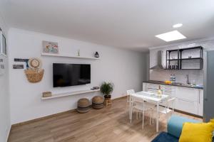 阿里纳加Sunny Winter Arinaga的白色的客厅配有桌子和厨房