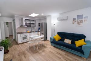 阿里纳加Sunny Winter Arinaga的一间带蓝色沙发的客厅和一间厨房