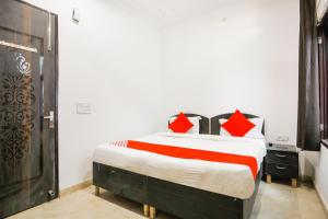 古尔冈OYO Welcome Residency的一间卧室配有一张带红色枕头的大床